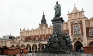 Pomnik Adama Mickiewicza na Rynku w Krakowie, z Sukiennicami w tle.
