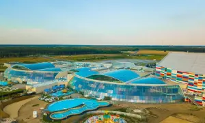 Widok z lotu ptaka na największy aqua park w Europie z błękitnymi dachami i kolorowym budynkiem.