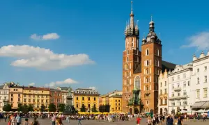 Rynek Główny w Krakowie tętni życiem. W tle Bazylika Mariacka i kolorowe kamienice.