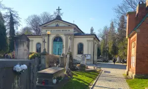 Cmentarz Rakowicki, z kaplicą i nagrobkami, w słoneczny dzień.