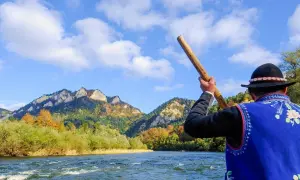 Flisacy Dunajec w tradycyjnych strojach płyną tratwą przez malowniczy przełom rzeki. Góry Pieniny jesienią zachwycają kolorami.