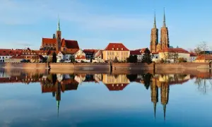 Wrocław wydarzenia na weekend: Katedra i zabytkowe kamieniczki odbijają się w spokojnej tafli Odry.