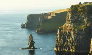 Klify Moheru – obowiązkowy punkt na mapie "Irlandia co zobaczyć". Majestatyczne skały wpadające do oceanu, z wieżą widoczną na szczycie.