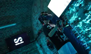 Chłopak w goglach VR w Krakowie, zanurzony w wirtualnej rzeczywistości. Na ekranie logo VRStudio.