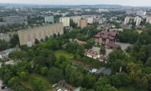 Widok na osiedle mieszkaniowe i kościół, przypominający o historii Krakowa.