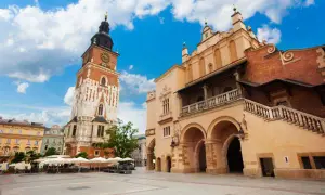 Wieża ratuszowa Kraków na Rynku Głównym, obok Sukiennic, pod błękitnym niebem.