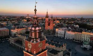 Zachód słońca nad Rynkiem Głównym w Krakowie. Widać wieżę Ratuszową i Kościół Mariacki, ikoniczne kraków zabytki.