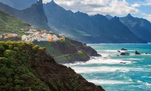 Kolorowe domki na zboczu klifu, zieleń i turkus oceanu. Idealny maj na Wyspach Kanaryjskich.