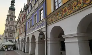 Zamość co zobaczyć: kolorowe kamienice z arkadami i wieża ratuszowa tworzą malowniczy widok.