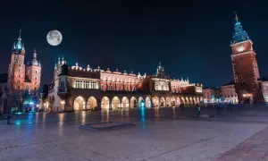 Kraków nocą. Sukiennice i Kościół Mariacki pod księżycem. Wieża Ratuszowa góruje nad Rynkiem.