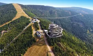 Widok na Sky Walk i wiszący most w Czechach, otoczony gęstym lasem i górskimi zboczami.