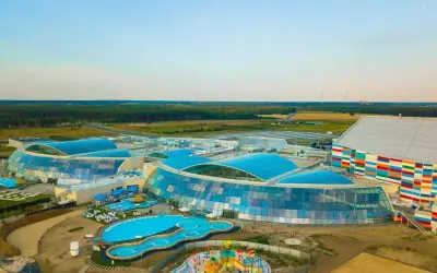 Widok z lotu ptaka na największy aqua park w Europie z błękitnymi dachami i kolorowym budynkiem.