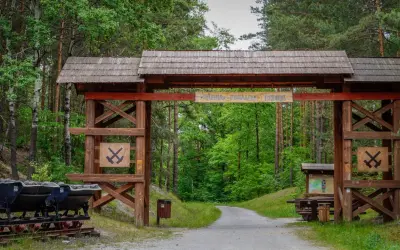 Drewniana brama zaprasza do zwiedzania dawnej kopalni w Babinie. To jedna z lubuskich atrakcji, gdzie można zobaczyć górnicze wózki i poznać historię.