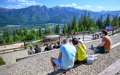 Widok na Tatry z widowni, gdzie ludzie odpoczywają, ciesząc się atrakcjami Poronina.