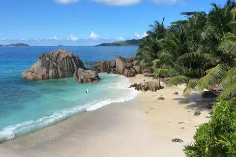 Rajska plaża z palmami i granitowymi skałami. Czy to Mauritius czy Seszele? Woda kusi turkusowym kolorem.