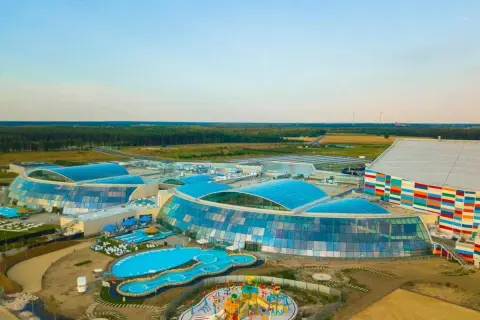Widok z lotu ptaka na największy aqua park w Europie z błękitnymi dachami i kolorowym budynkiem.