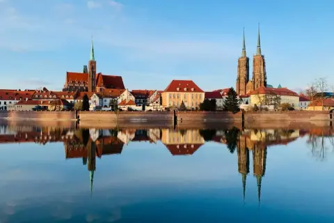 Wrocław wydarzenia na weekend: Katedra i zabytkowe kamieniczki odbijają się w spokojnej tafli Odry.