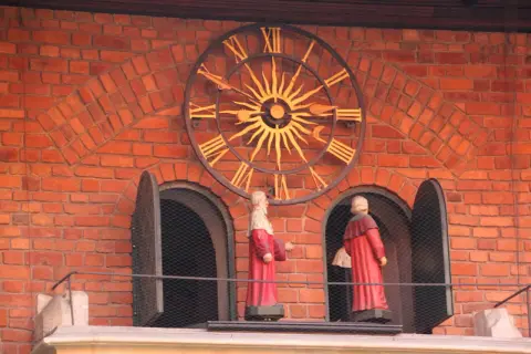 Figury na Collegium Maius przy zegarze słonecznym.