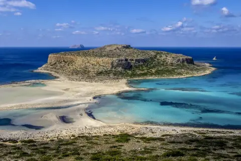 Malownicza zatoka z turkusową wodą i piaszczystą plażą, otoczona skalistymi klifami. To raj dla miłośników przyrody, ukazujący walory przyrodnicze Grecji.