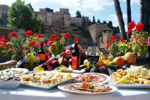 Uczta w jednej z malaga restauracji: tapas, wino i owoce na tle Alcazaby.