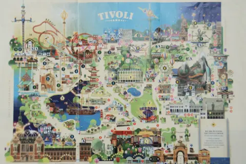 Mapa parku rozrywki Tivoli z atrakcjami, kolejkami górskimi i budynkami.