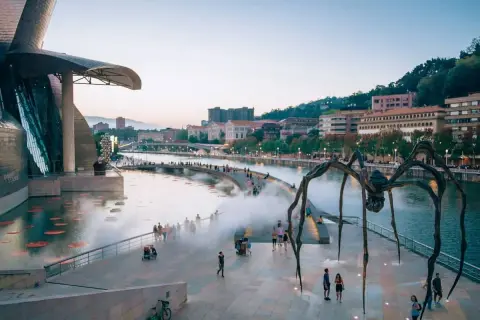 Gigantyczny pająk strzeże Muzeum Guggenheima w Bilbao. Wspaniałe bilbao atrakcje zachwycają o zmierzchu.