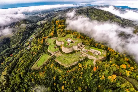 Fortecę na wzgórzu otaczają jesienne lasy. Srebrna Góra oferuje wspaniałe widoki i historyczne atrakcje.