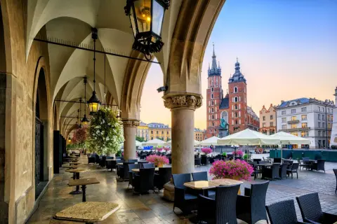 Krakowskie Sukiennice, co to? To historyczne miejsce z kawiarnianymi stolikami i widokiem na Kościół Mariacki.