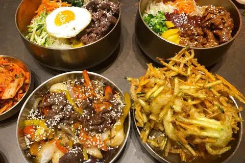 Pyszne dania kuchni koreańskiej w nooks Poznań: bibimbap, bulgogi i chrupiące warzywa w tempurze.