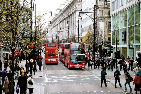 Tłum ludzi i czerwone piętrowe autobusy na najsłynniejszej ulicy w Londynie, Oxford Street.
