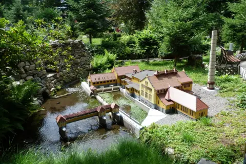 Miniaturowa zabudowa z mostkiem i rzeką, część największego parku miniatur w Polsce.