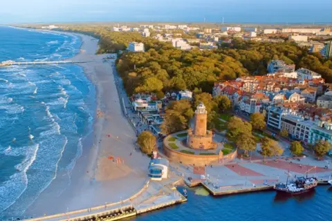 Widok na plażę, morze i latarnię morską. Idealne miejsce, gdzie najlepiej nad morze, z promenadą i portem.