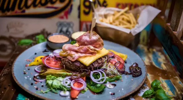 Pyszny burger z bekonem, serem i warzywami. Prawdziwe niebo w gębie w Karpaczu! Do tego frytki i sosy.