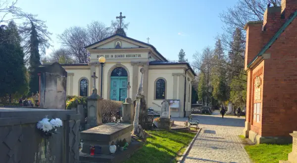 Cmentarz Rakowicki, z kaplicą i nagrobkami, w słoneczny dzień.