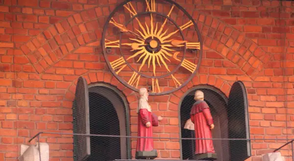Figury na Collegium Maius przy zegarze słonecznym.