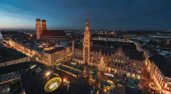Nocne monachium zwiedzanie: Rynek Główny z jarmarkiem bożonarodzeniowym, Nowy Ratusz i Frauenkirche w blasku świateł.