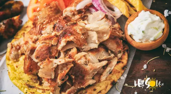 Pyszne jedzenie w Grecji: gyros z kurczaka na chlebku pita, z pomidorami, cebulą, frytkami i sosem tzatziki.