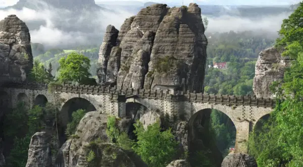 Kamienny most Bastei, jedna z najpiękniejszych atrakcji turystycznych Saksonii, wznosi się nad skalistym wąwozem, otoczony mglistymi górami.