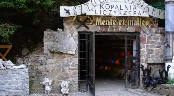 Kowary atrakcje: wejście do Sztolni Liczyrzepa, kamienne krasnale i kamienne rzeźby.