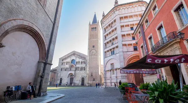 Parma co zobaczyć: Piazza Duomo z katedrą, baptysterium i wieżą. Muzyk gra na akordeonie.