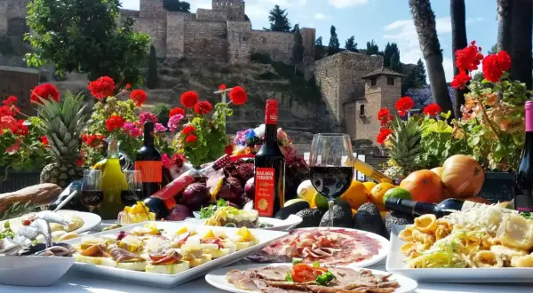 Uczta w jednej z malaga restauracji: tapas, wino i owoce na tle Alcazaby.