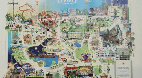 Mapa parku rozrywki Tivoli z atrakcjami, kolejkami górskimi i budynkami.