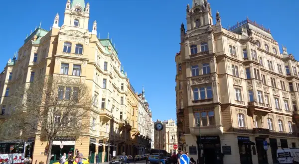 Architektura w dzielnicy żydowskiej Pragi, z secesyjnymi kamienicami i błękitnym niebem.