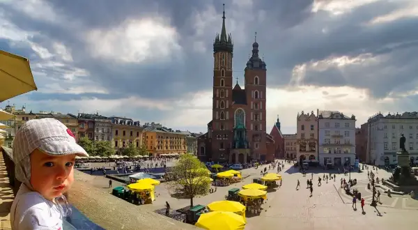 Mały chłopiec na Rynku Głównym w Krakowie, gdzie znajdziesz wiele darmowych atrakcji dla dzieci.