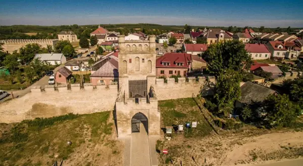 Brama wjazdowa do Szydłowa, z murami obronnymi i zabudowaniami. To jedne z głównych szydłów atrakcje, które warto zobaczyć.