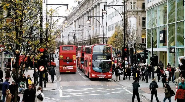 Tłum ludzi i czerwone piętrowe autobusy na najsłynniejszej ulicy w Londynie, Oxford Street.