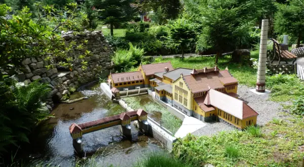 Miniaturowa zabudowa z mostkiem i rzeką, część największego parku miniatur w Polsce.