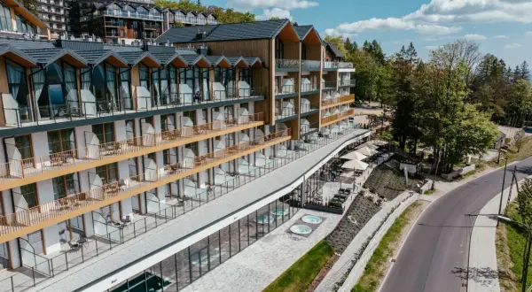 Nowoczesny hotel ze złotymi balkonami i tarasami, z widokiem na las. Złoty horyzont resort szklarska poręba zaprasza na relaks.