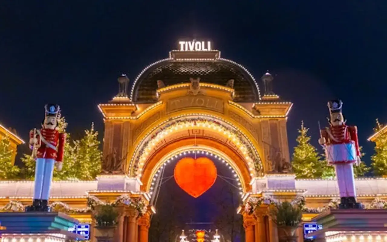 Nocny park Tivoli rozświetlony tysiącami lampek. Wspaniała brama wejściowa z napisem 