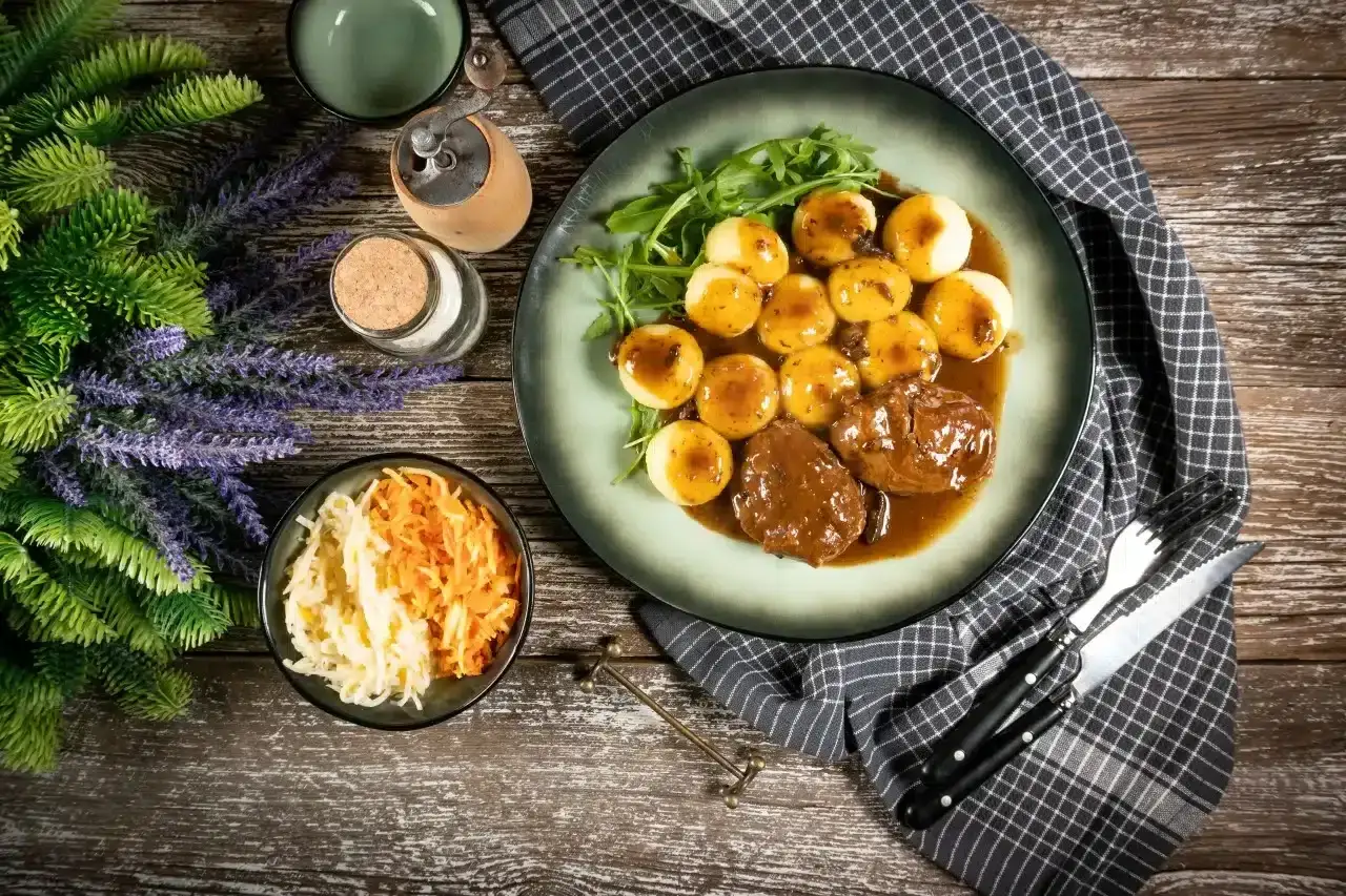 Tradycyjne jedzenie w Niemczech: pieczeń wołowa w sosie z kluskami ziemniaczanymi i surówką z kapusty.